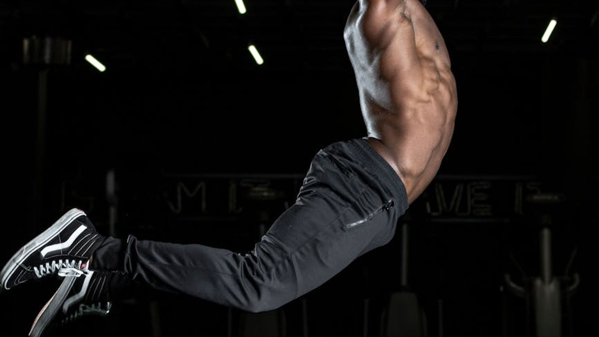 Person doing dynamic cardio movements in dark studio