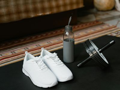 Sports shoes and water bottle on a black floor